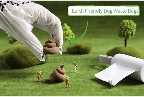 Gloved hand holding earth friendly dog waste bag over miniature lawn scene with tiny figures and trees